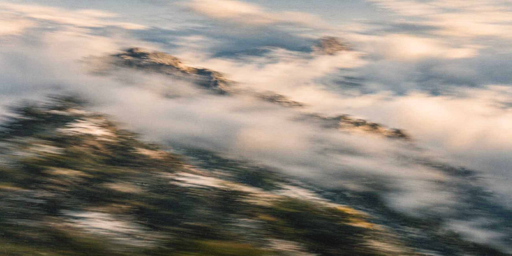 Photo abstraite, floue par le mouvement : sommets rocheux dans une mer de nuages